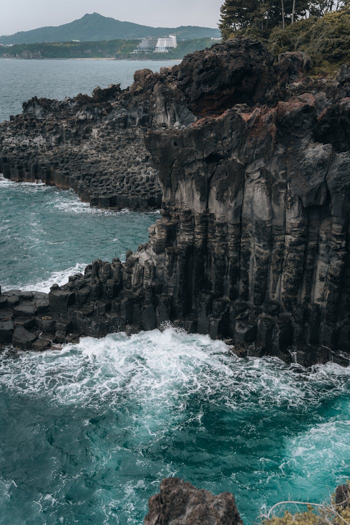 services-02 Dramatic cliffs and vibrant ocean waves at Jeju Island's stunning shoreline.